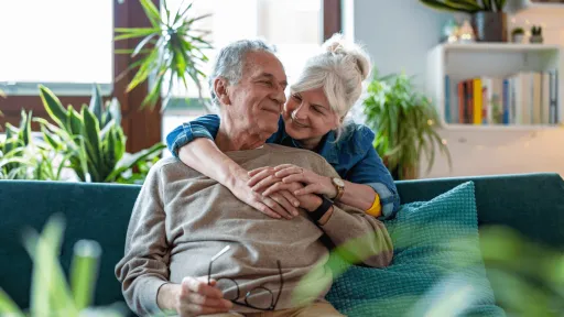 Elderly man and woman on couch surrounded by greenery