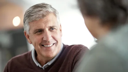 Shot of a mature man having a conversation with someone blurred out in the foreground