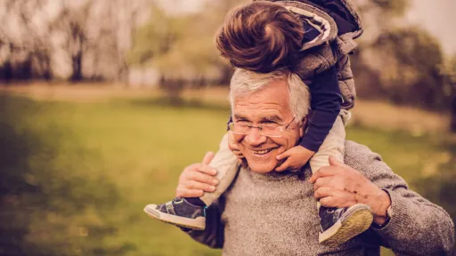 Grandparent carrying grandchild on shoulders