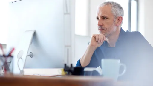 Low angle view of a mature professional man looking intently at his pc