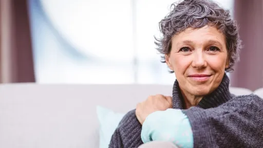 Portrait of smiling mature woman sitting on sofa at home