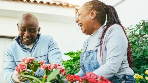 Multiracial women preparing flowers plants at home patio garden