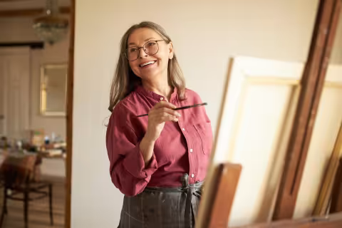 Woman enjoying painting on an easel